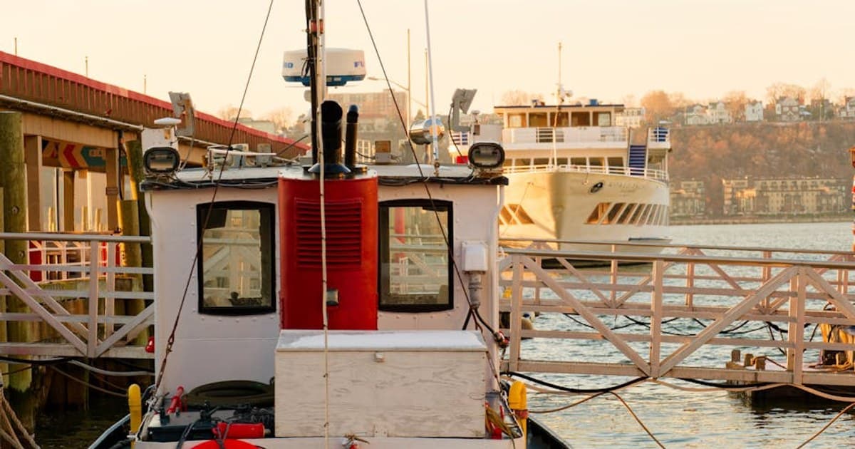 Fishing boat docked at a tranquil New York harbor during sunset, capturing vibrant reflections.