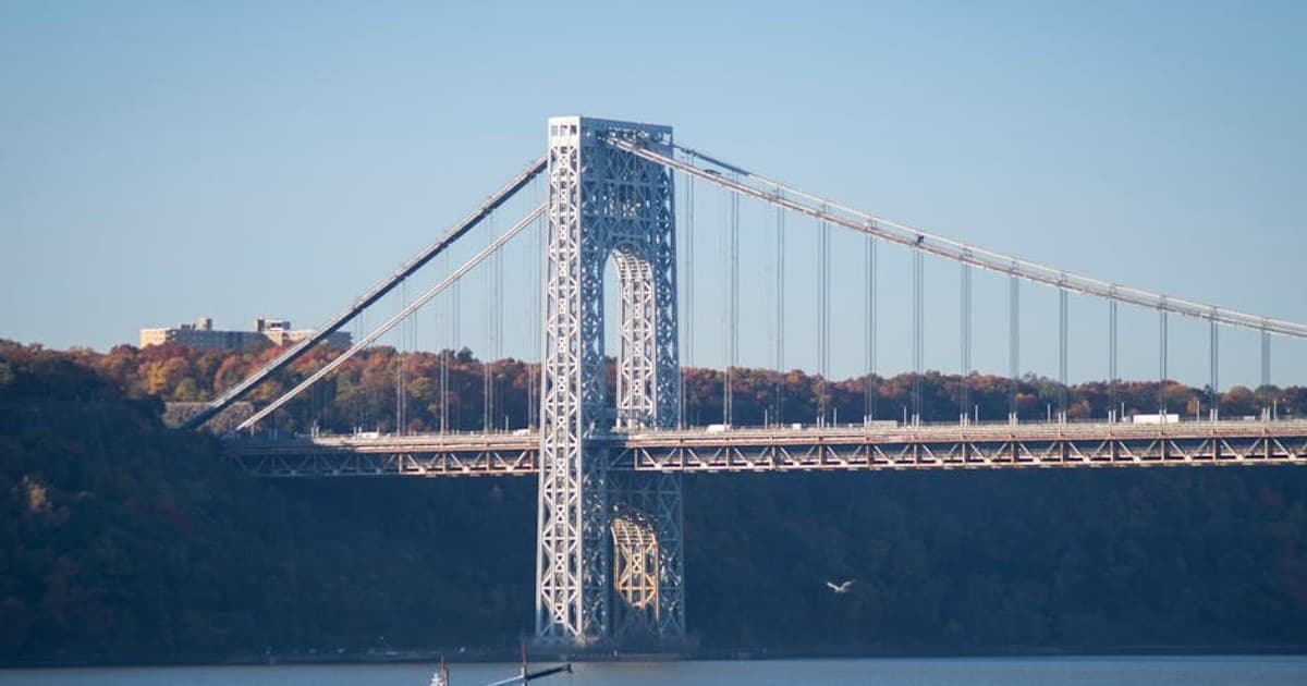 View of George Washington Bridge spanning Hudson River with autumn foliage.