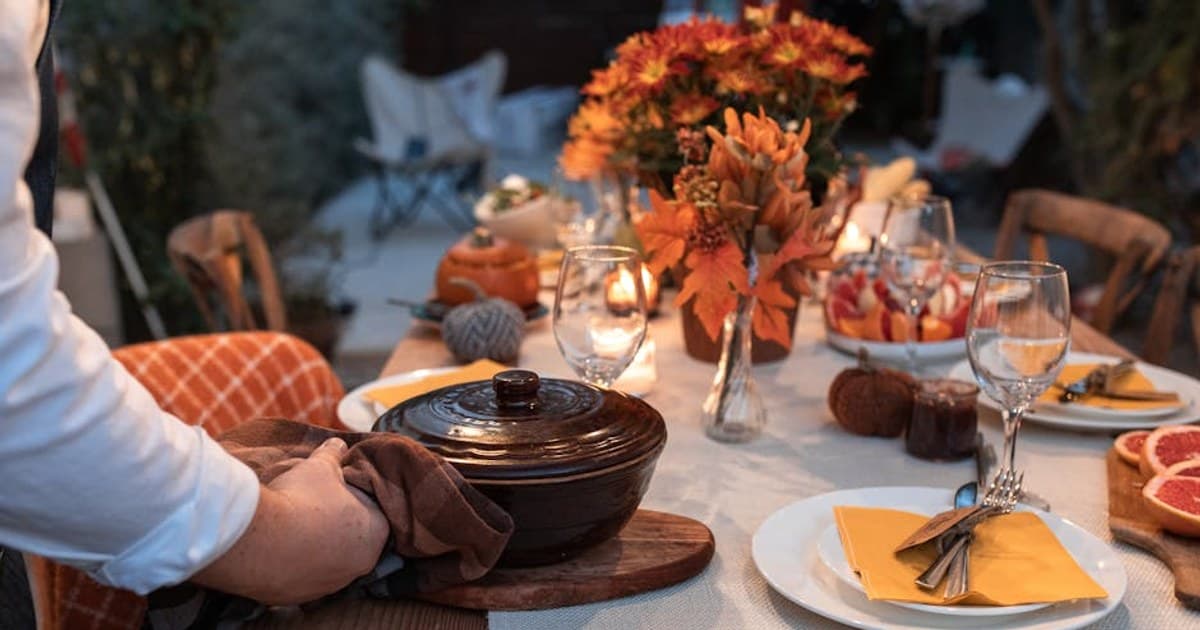 Beautifully arranged autumn table setting with festive decorations and a serving pot.