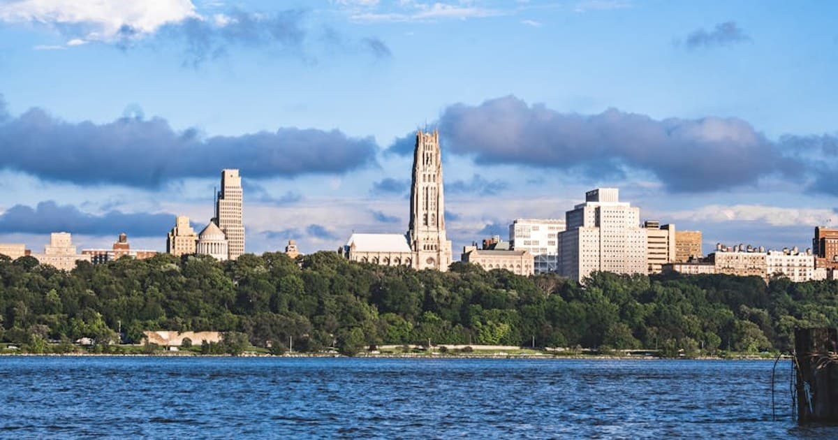 View of Riverside Church and New York skyline across the Hudson River on a sunny day.
