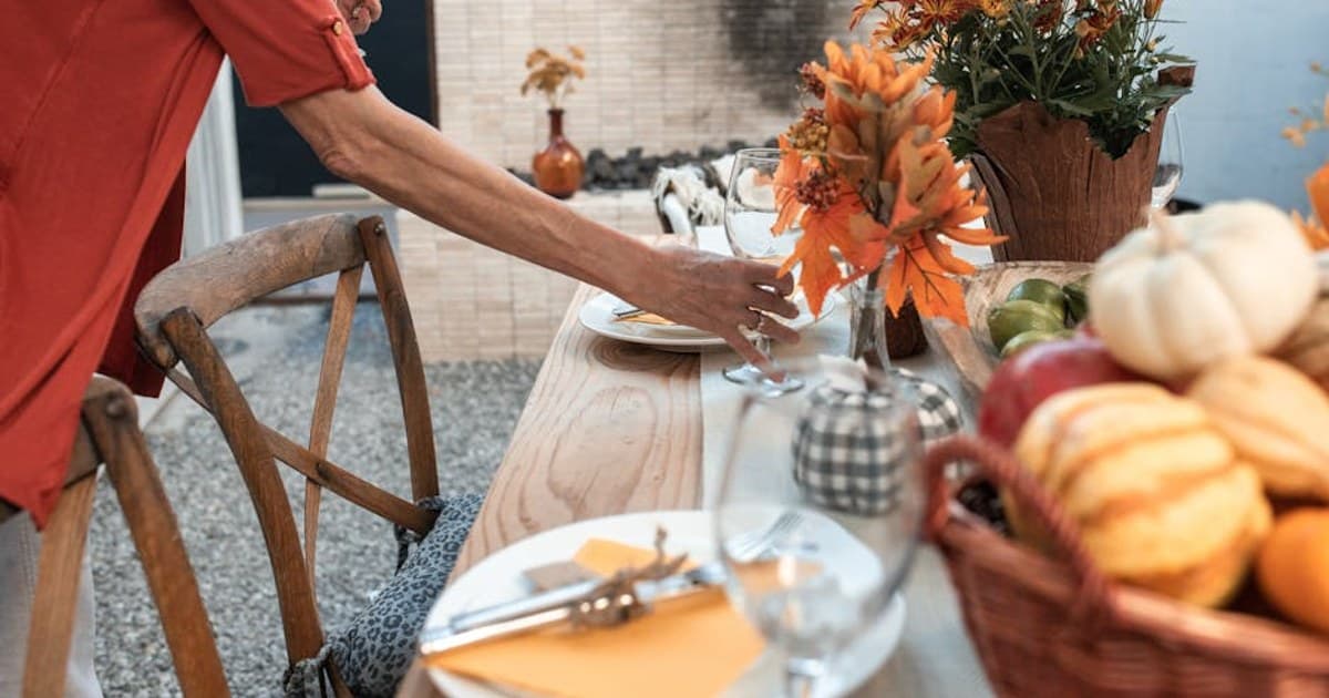 An inviting fall-themed table setting with autumn flowers and decorations for Thanksgiving.