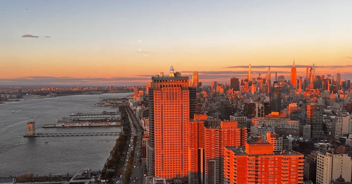 Stunning aerial view of Manhattan skyscrapers glowing in sunset light.