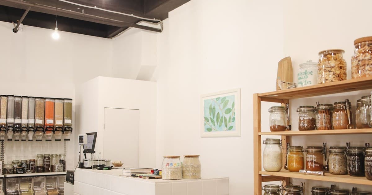 Eco-friendly shop interior featuring wooden shelves and bulk food storage for zero waste shopping.